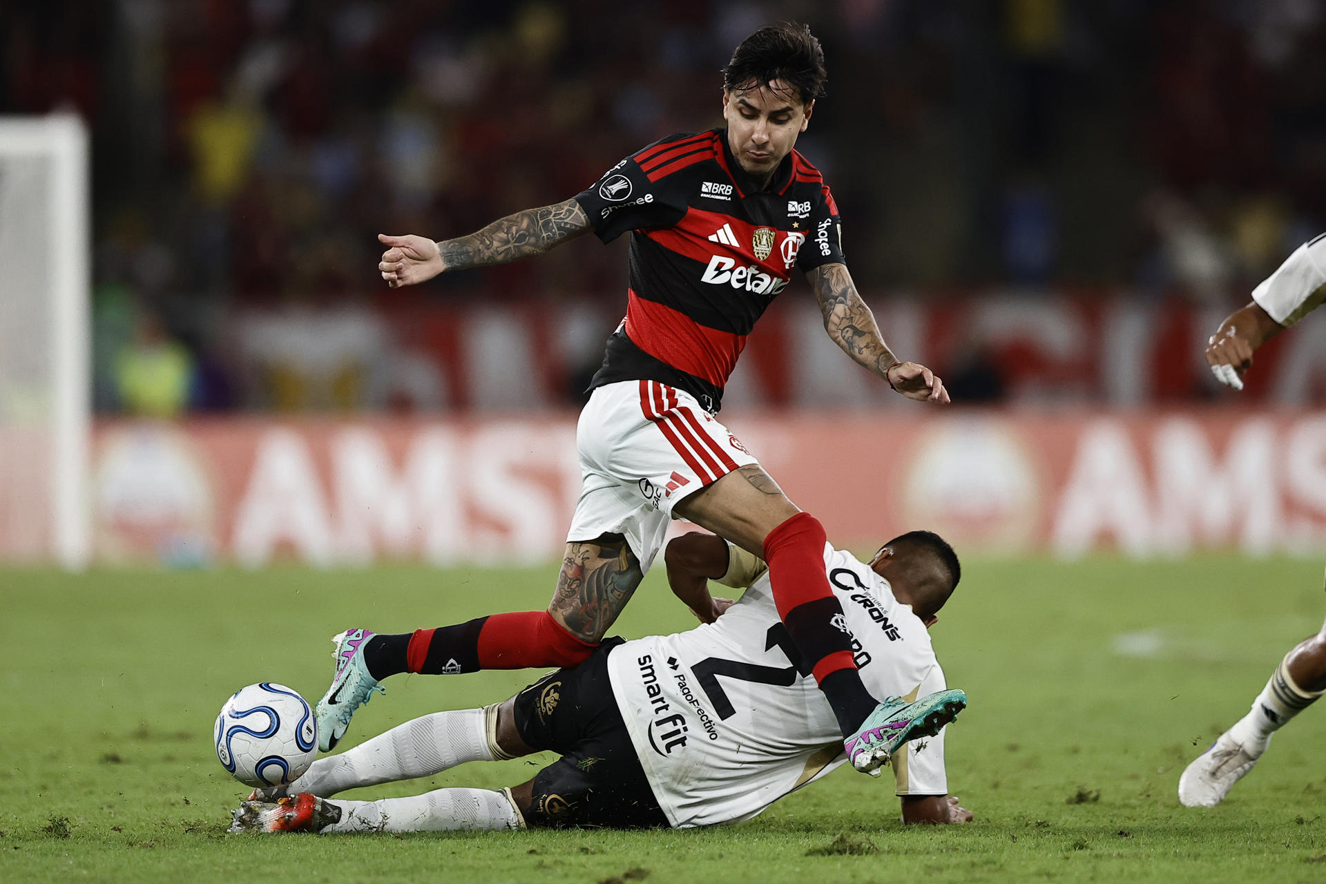 Erick Pulgar (c), de Flamengo, disputa el balón con Carlos Gamarra (abajo), de Cusco, durante un partido de la fase de grupos de la Copa Libertadores entre Flamengo y Cusco en el estadio Maracaná en Rio de Janeiro (Brasil). EFE/André Coelho
