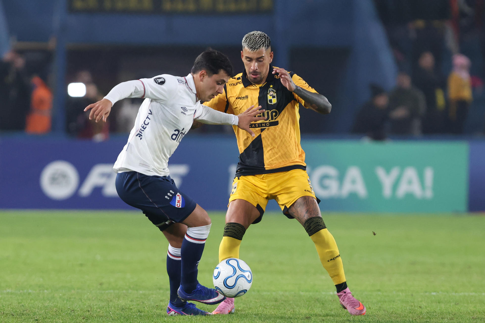 Rodrigo Martínez (i), de Nacional, disputa un balón con Salvador Cordero, de Coquimbo, durante un partido de la fase de grupos de la Copa Libertadores entre el Club Nacional y Coquimbo Unido en el estadio Gran Parque Central en Montevideo (Uruguay). EFE/Gastón Britos
