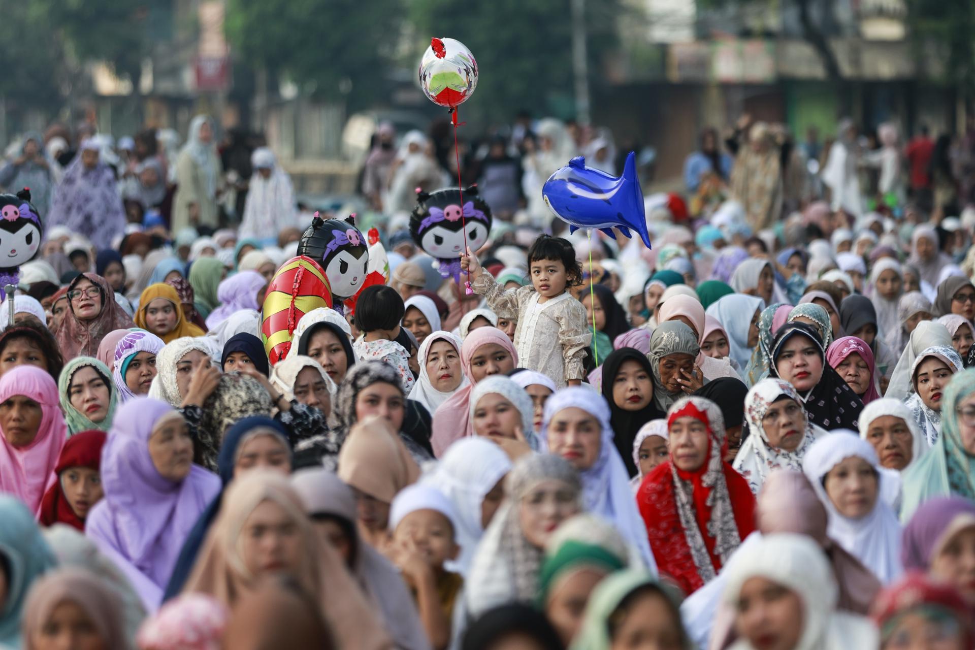 YAKARTA (Indonesia), 27/05/2026.- Un niño sostiene un globo mientras la gente reza en una calle durante la festividad musulmana de Eid al-Adha en Yakarta, Indonesia, el 27 de mayo de 2026.
EFE/EPA/MAST IRHAM