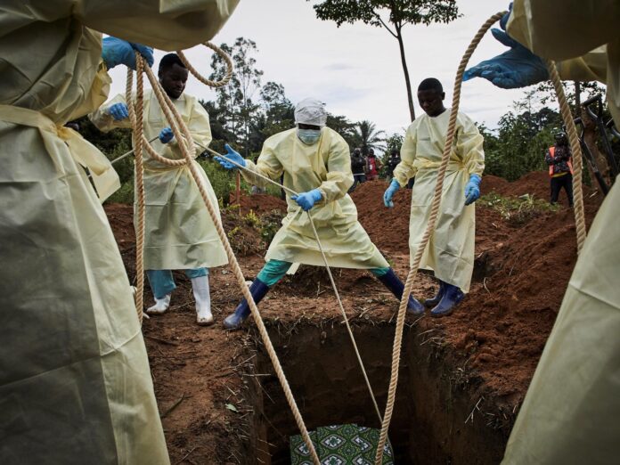 FOTO ARCHIVO. Trabajadores sanitarios bajan el ataúd de Kakule Mbusa Desire, víctima del ébola, en Beni, provincia de Kivu del Norte, República Democrática del Congo. EFE/EPA/HUGH KINSELLA CUNNINGHAM
