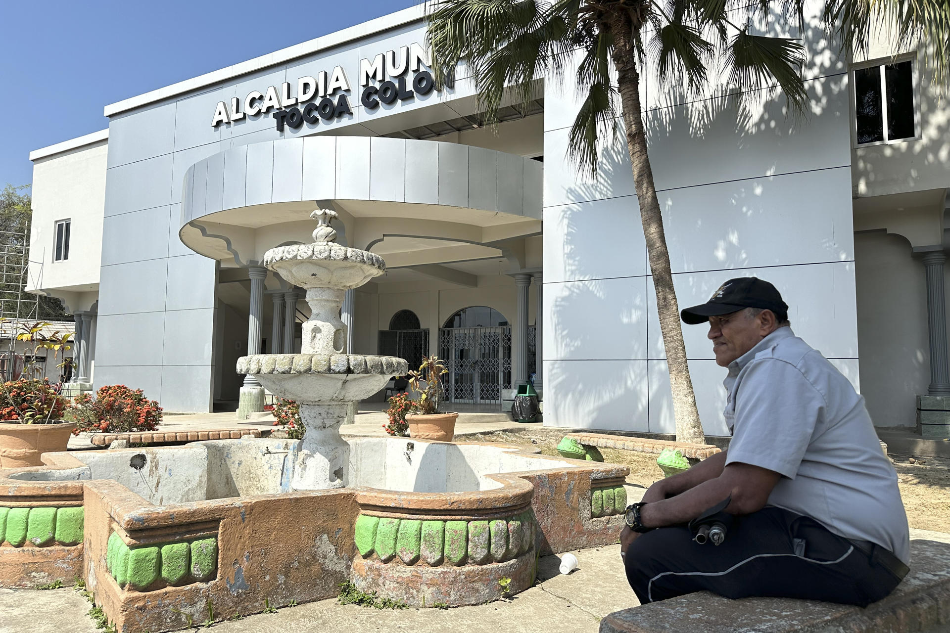 Fotografía del 23 de mayo de 2026 que muestra una persona sentada frente al edificio de la Alcaldía Municipal de Tocoa, en Colón (Honduras). EFE/ Germán Reyes
