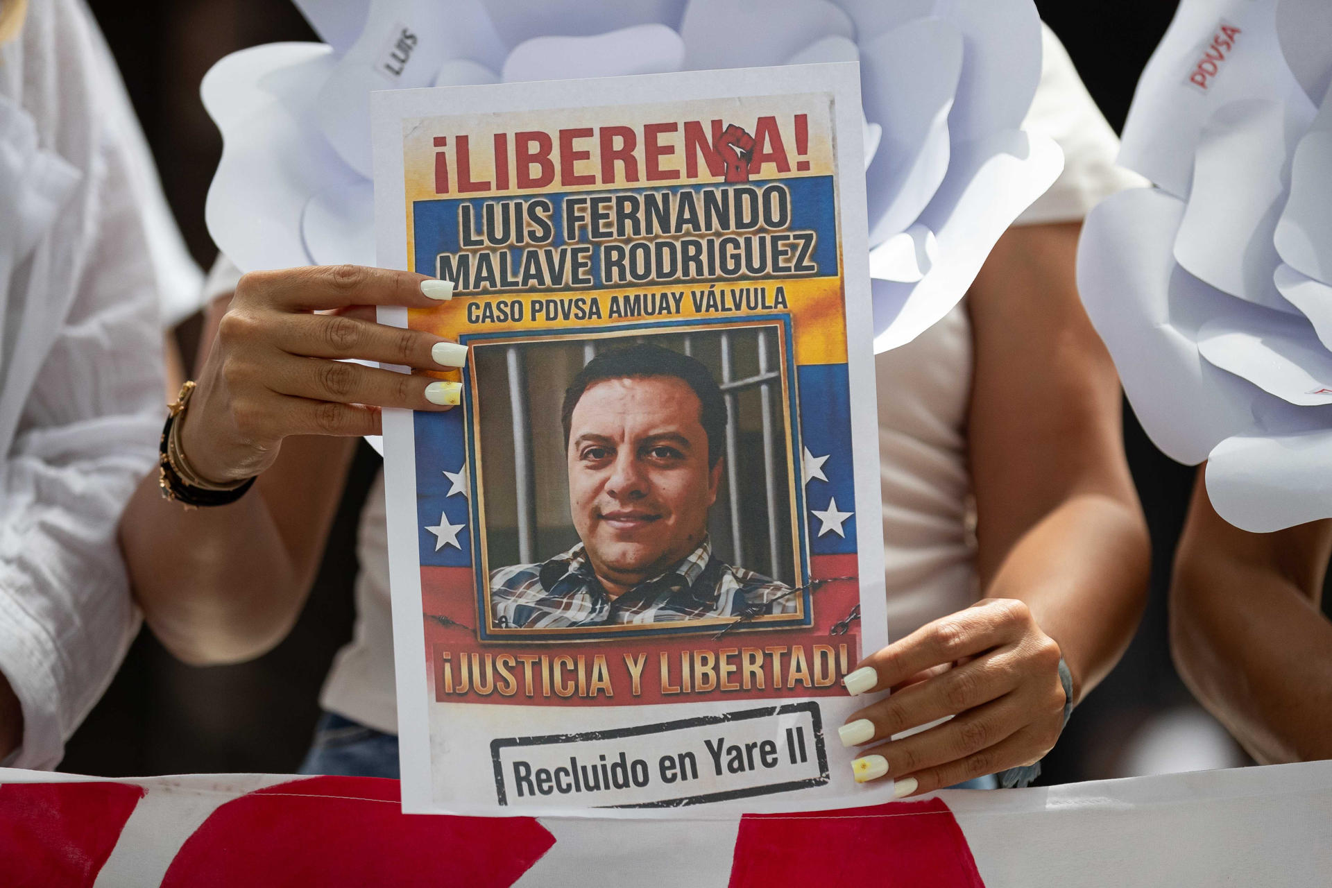 Detalle de un cartel sostenido por una mujer, este 27 de mayo, que pide la libertad de una persona vinculada a un presunto caso de contrabando en la estatal Petróleos de Venezuela (Pdvsa), en Caracas (Venezuela). EFE/Ronald Peña
