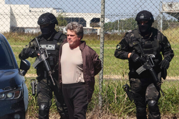 Gerson Palermo (c), considerado uno de los narcotraficantes más buscados en Brasil, fue captado, este 27 de mayo, al ser es custodiado por integrantes de la Fuerza Especial de Lucha Contra el Narcotráfico de Bolivia (FELCN), en Santa Cruz (Bolivia). EFE/Juan Carlos Torrejon
