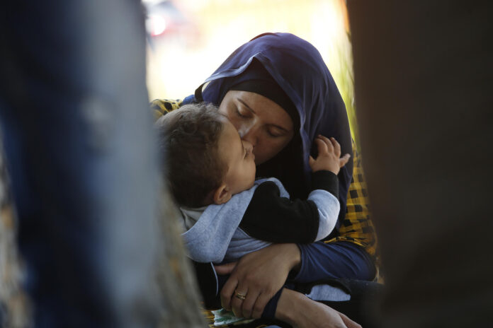 Fotografía de archivo de una madre al besar su hijo, frente a la sede local de la ONU, en Santiago de Chile (Chile). EFE/Elvis González
