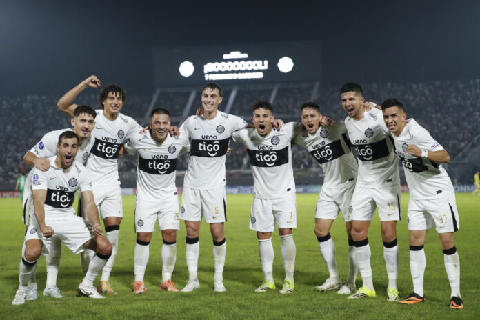 Jugadores de Olimpia celebran la clasificación a los octavos de final de la Copa Sudamericana tras vencer este miércoles de remontada por 3-1 al Audax Italiano en el estadio asunceno Defensores del Chaco. EFE/ Juan Pablo Pino
