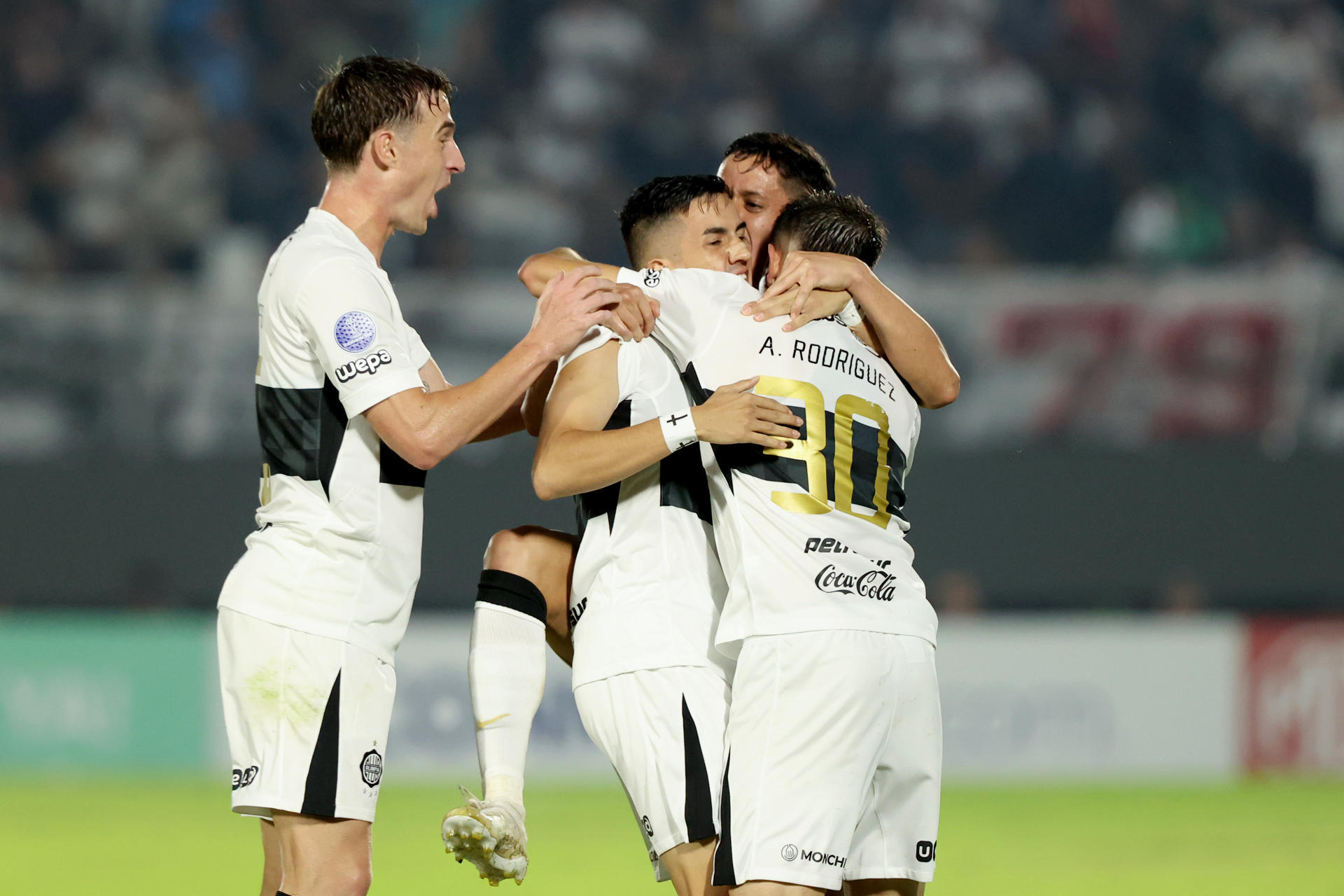 Jugadores de Olimpia celebran la clasificación a los octavos de final de la Copa Sudamericana tras vencer este miércoles de remontada por 3-1 al Audax Italiano en el estadio asunceno Defensores del Chaco. EFE/ Juan Pablo Pino
