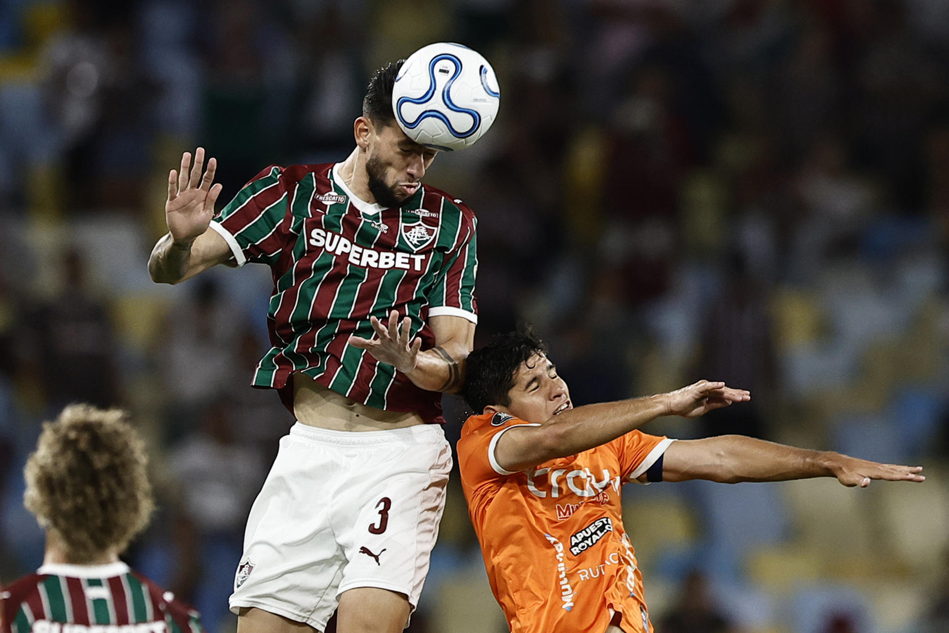 Jemmes (i) de Fluminense gana en el salto por el balón a Miguel González de La Guaira durante el partido que clasificó este miércoles al equipo brasileño a los octavos de final de la Copa Libertadores en el estadio Maracaná de Río de Janeiro. EFE/ André Coelho
