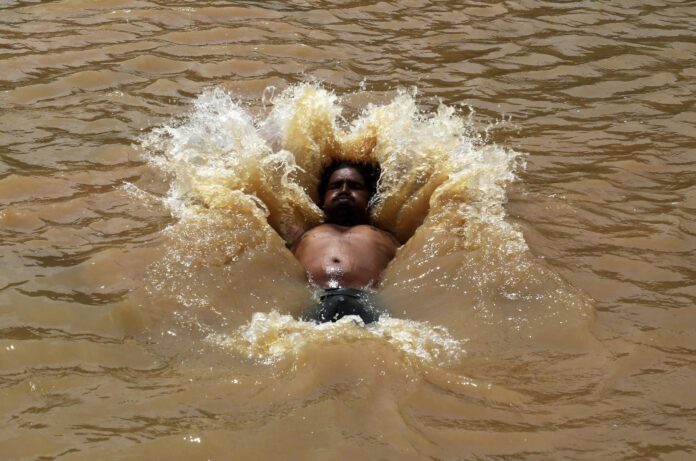 En la imagen de archivo, un hombre se da un baño para combatir una ola de calor en la localidad de Gauribidanur, en el distrito de Doddaballapur, la India. EFE/Jagadeesh Nv
