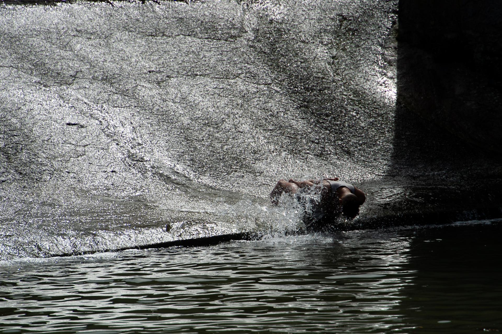 En la imagen de archivo, un joven se zambulle en el río Arga, a su paso por Pamplona (España). EFE/Iñaki Porto.
