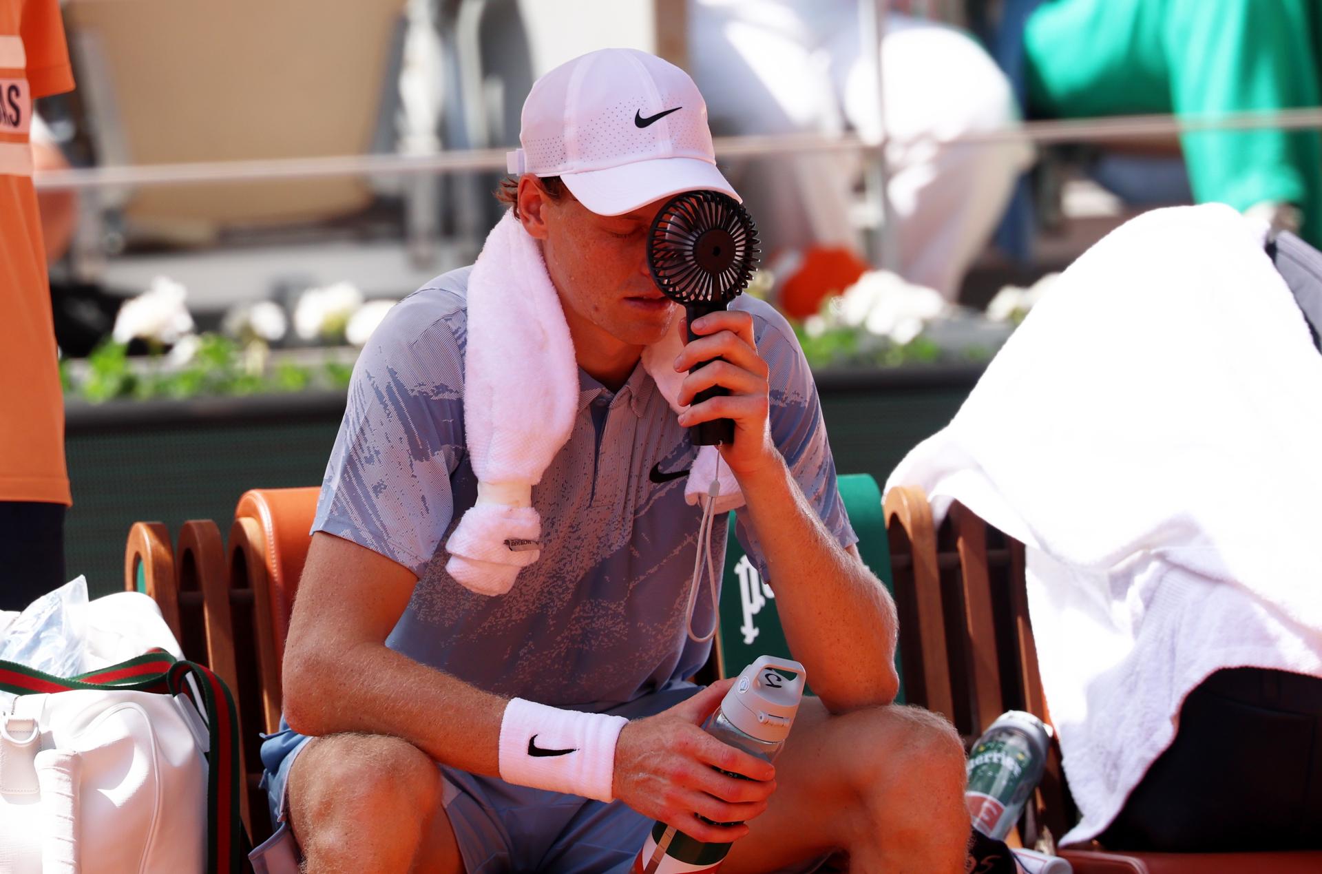 El italiano Jannik Sinner intenta refrescarse durante su partido de segunda ronda de Roland Garros, disputado este jueves ante el argentino Juan Manuel Cerúndolo. EFE/ MOHAMMED BADRA
