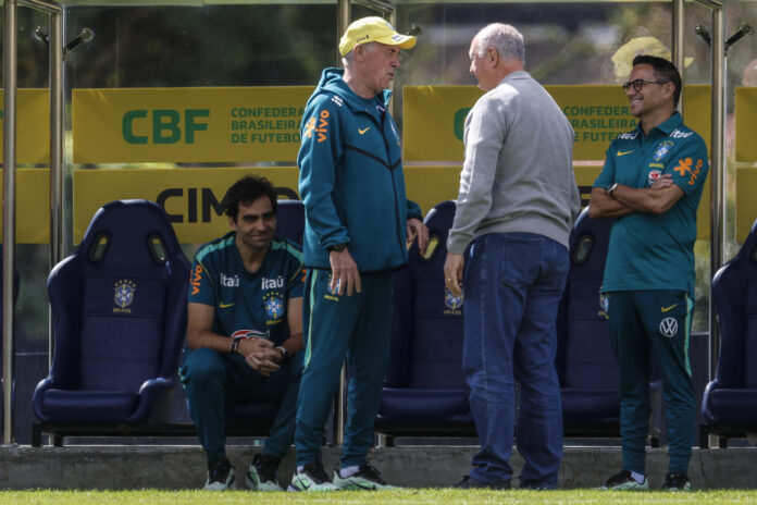 El seleccionador de Brasil, Carlo Ancelotti (c), habla con el exseleccionador y campeón del mundo en 2002, Luiz Felipe Scolari (c-d), y el director de fútbol de la selección brasileña, Rodrigo Caetano (d), durante un entrenamiento este jueves en la Granja Comary, en Teresópolis (Brasil). EFE/ Antonio Lacerda
