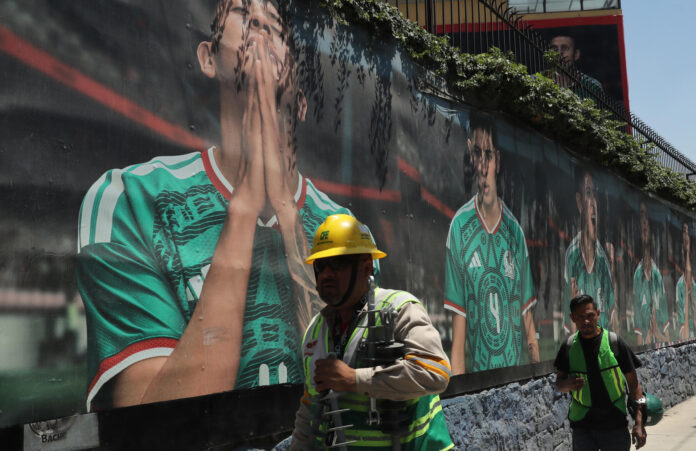 Personas caminan frente a un mural del Estadio Azteca (Banorte) en Ciudad de México (México). Fotografía de archivo. EFE/ Mario Guzmán
