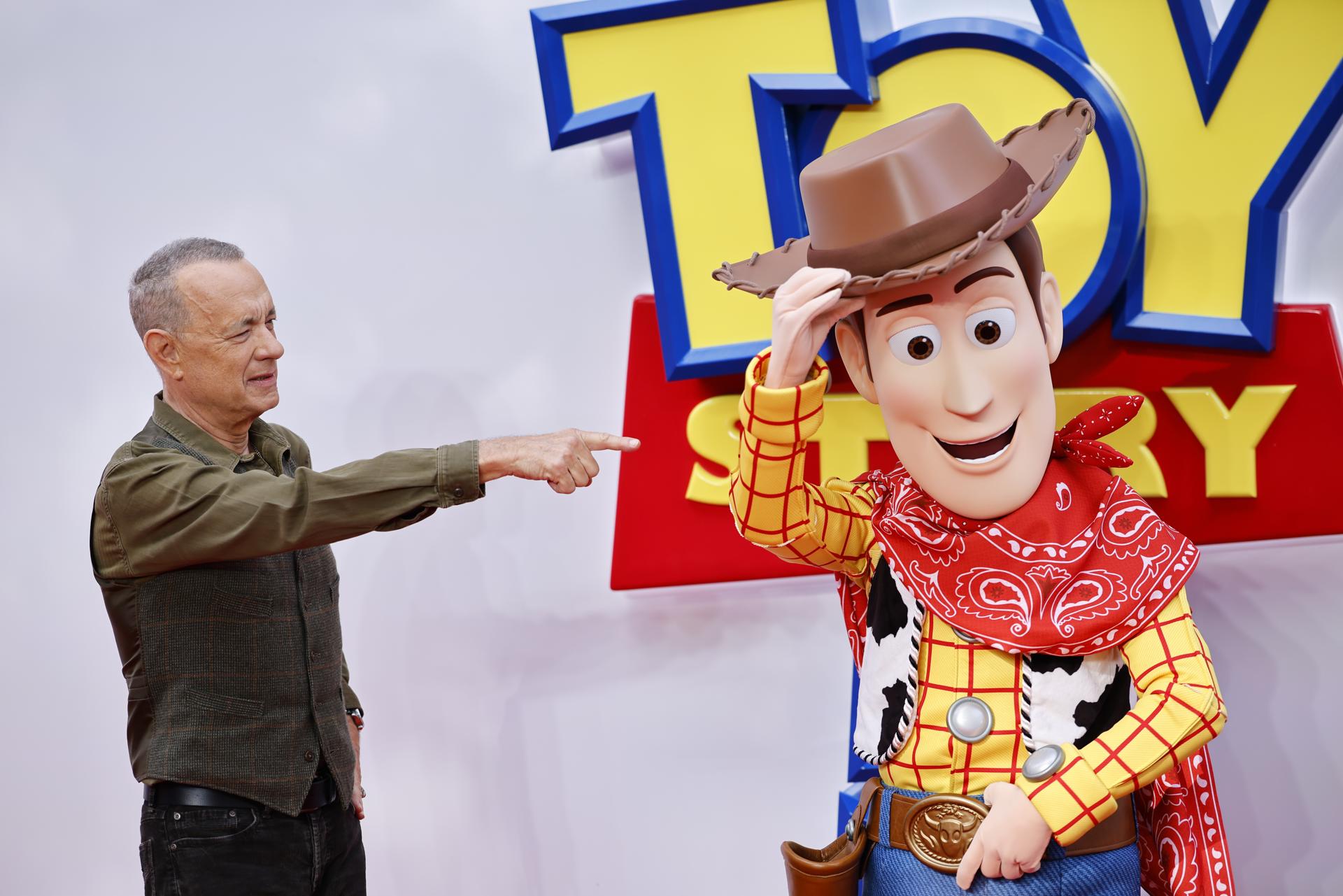 El actor estadounidense y miembro del reparto Tom Hanks (izquierda) señala al personaje Woody en el evento de lanzamiento de 'Toy Story 5' en el Odeon Luxe de Leicester Square, Londres. EFE/EPA/TOLGA AKMEN