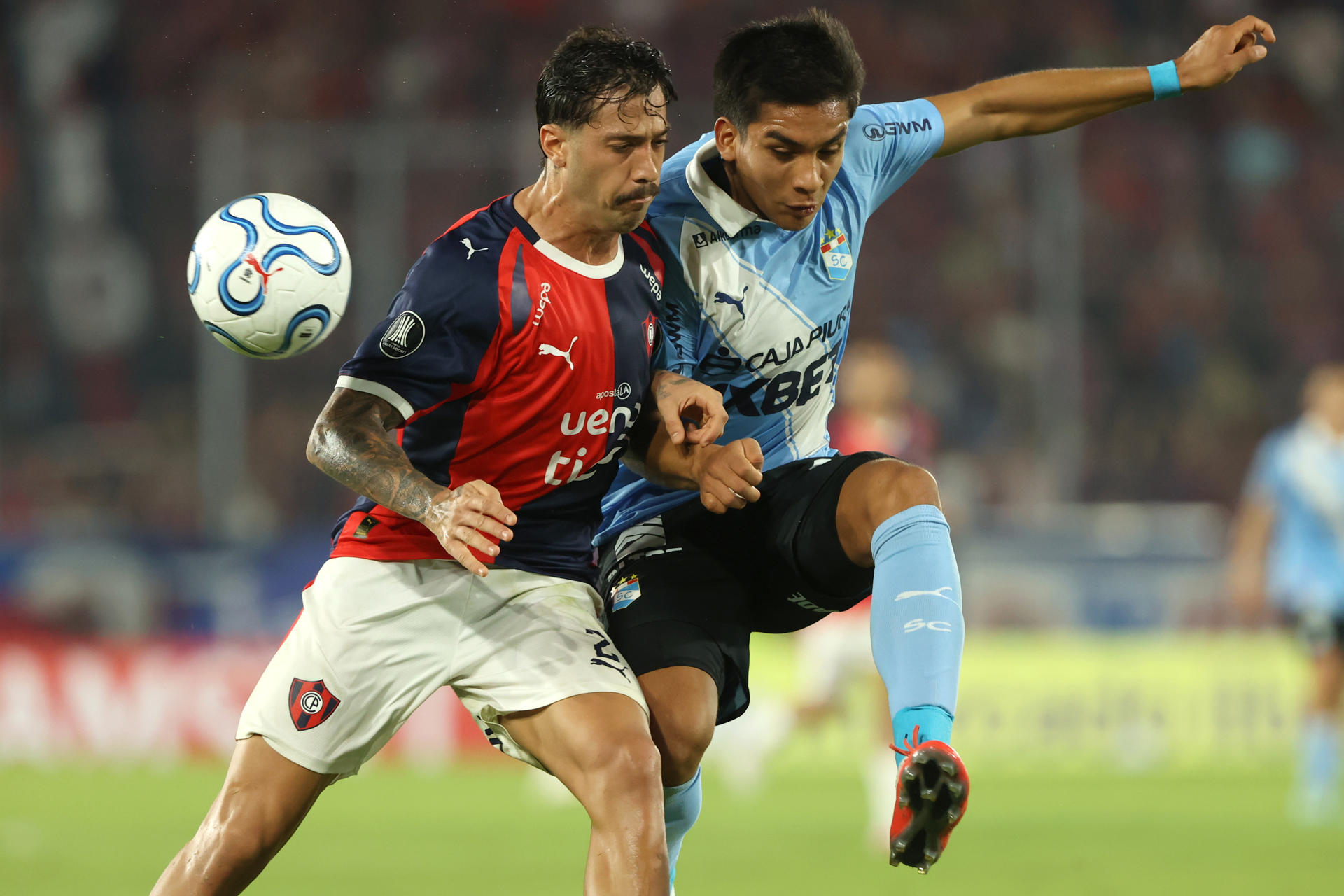 Fabricio Domínguez (i) de Cerro Porteño disputa el balón con Fabrizio Lora de Sporting Cristal este jueves durante el partido de la última jornada de la fase de grupos de la Copa Libertadores jugado en el estadio La Nueva Olla de Asunción. EFE/ Juan Pablo Pino
