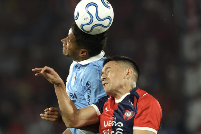 El lateral de Cerro Porteño Guillermo Benítez disputa el balón con el centrocampista brasileño  de Sporting Cristal, Gabriel Santana (i), durante el partido de la última jornada de la fase de grupos de la Copa Sudamericana jugado este jueves en el estadio La Nueva Olla, de Asunción. EFE/ Juan Pablo Pino
