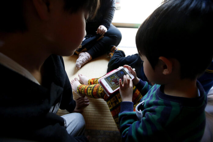 En la imagen de archivo, una niña juega con su teléfono en Japón. EPA/JEON HEON-KYUN
