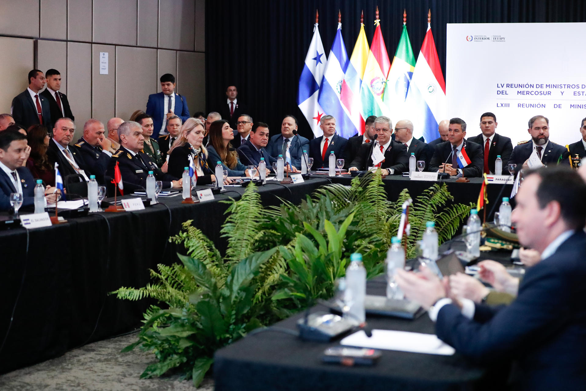 El presidente de Paraguay, Santiago Peña (c), habla junto al ministro del Interior, Enrique Riera (c-i), y el ministro de Justicia, Rodrigo Nicora (c-d), durante el acto de apertura de la LV Reunión de Ministros del Interior y de Seguridad del Mercosur y Estados Asociados, y de la LXIII Reunión de Ministros de Justicia, este viernes en Asunción (Paraguay). EFE/ Juan Pablo Pino
