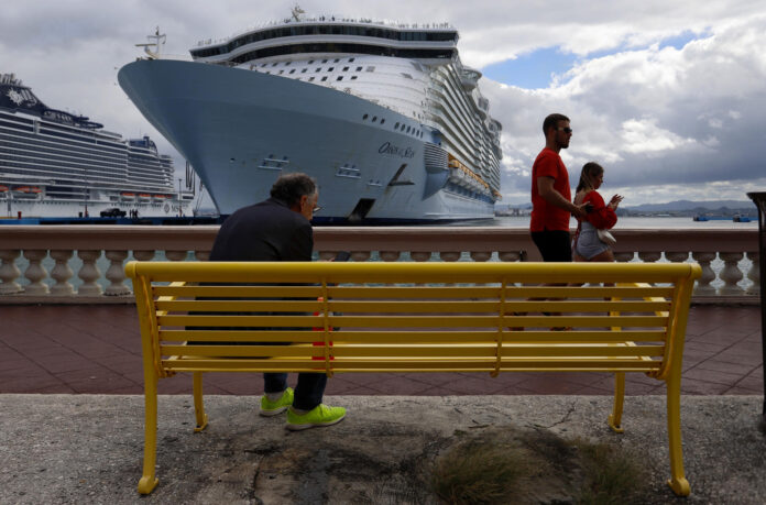 Fotografía de archivo de un grupo de personas al caminar frente a un crucero atracado en el Puerto de San Juan (Puerto Rico). EFE/Thais Llorca
