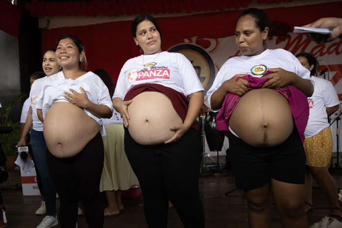 Mayerling López (i) ganadora del tercer lugar con una panza que mide 44 cm, Morelia Machado (c) ganadora del segundo lugar con una panza que mide 46 cm y Ana Rosa Vásquez ganadora del primer lugar con una panza que mide 48 cm posan durante el concurso 'La Madre Panza 2026' en Managua (Nicaragua). EFE/STR
