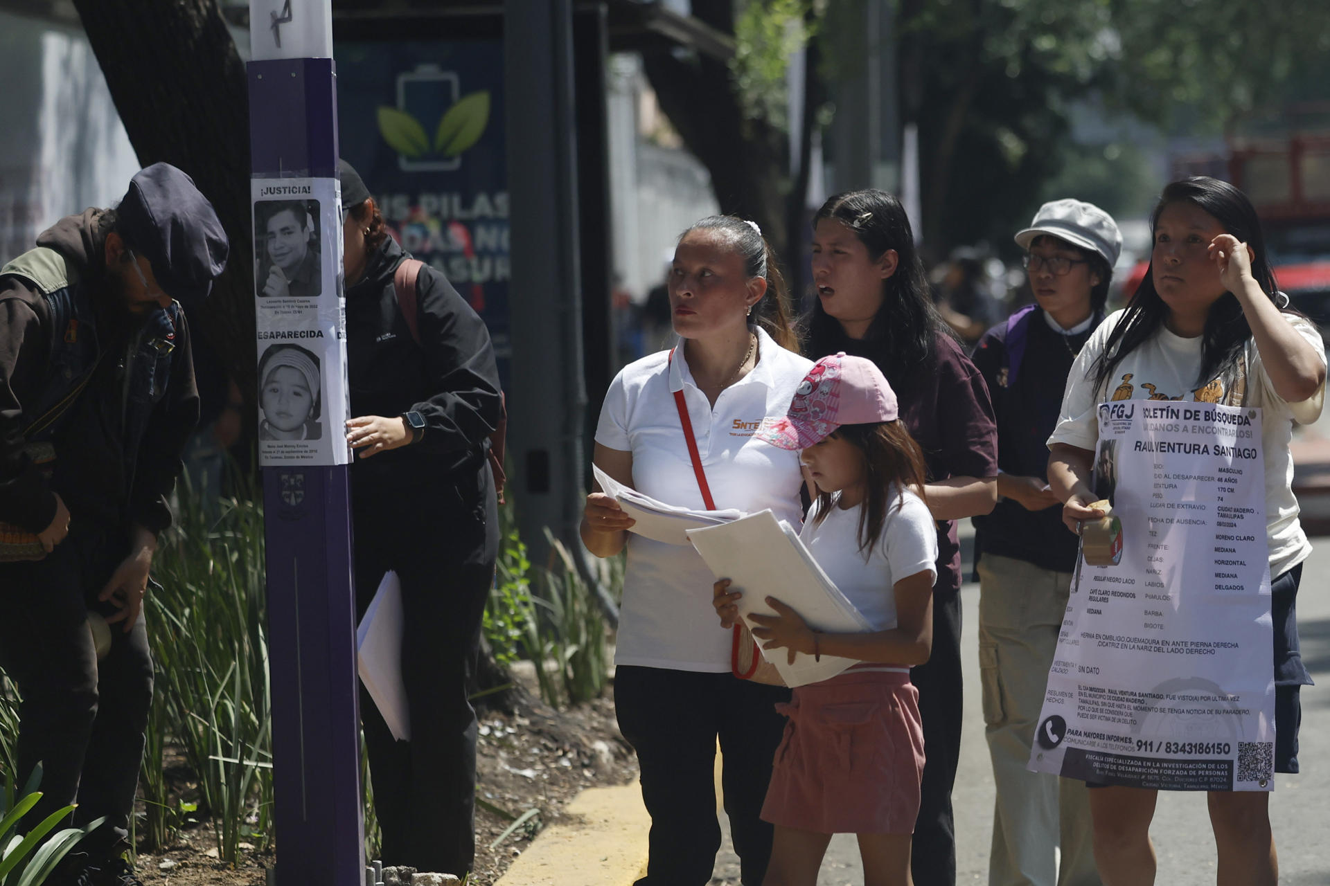 Familiares de personas desaparecidas pegan carteles de protesta este sábado, en Ciudad de México (México). EFE/ Sáshenka Gutiérrez
