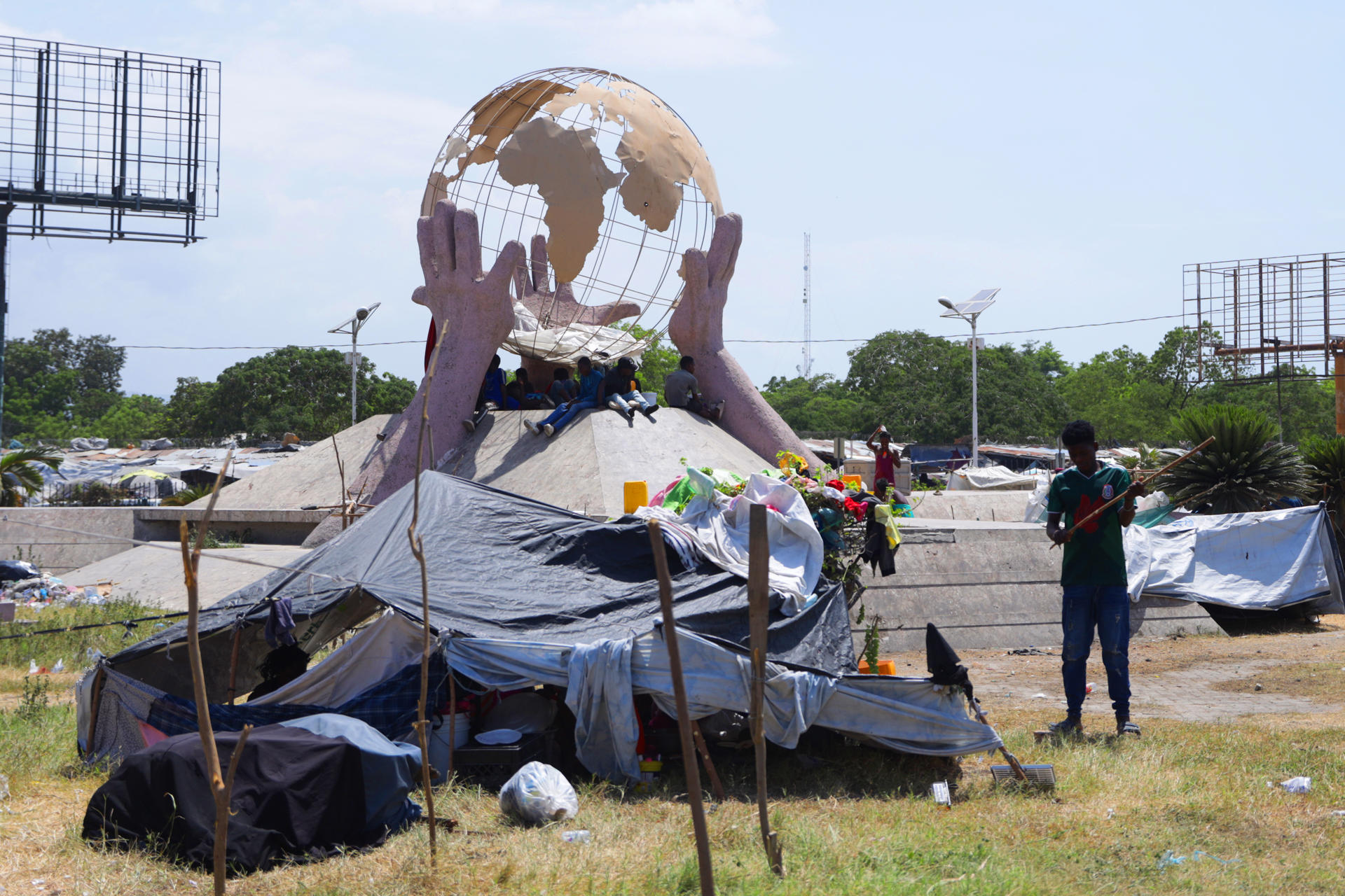 Familias desplazadas por la violencia caminan en una zona de viviendas improvisadas, cerca al aeropuerto internacional Toussaint Louverture en Puerto Príncipe (Haití). EFE/ Patrice Noel
