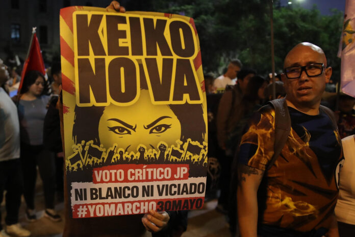 Personas sostienen carteles con la imagen de la candidata presidencial derechista Keiko Fujimori este sábado, durante una manifestación en su contra en Lima (Perú). EFE/ Paolo Aguilar
