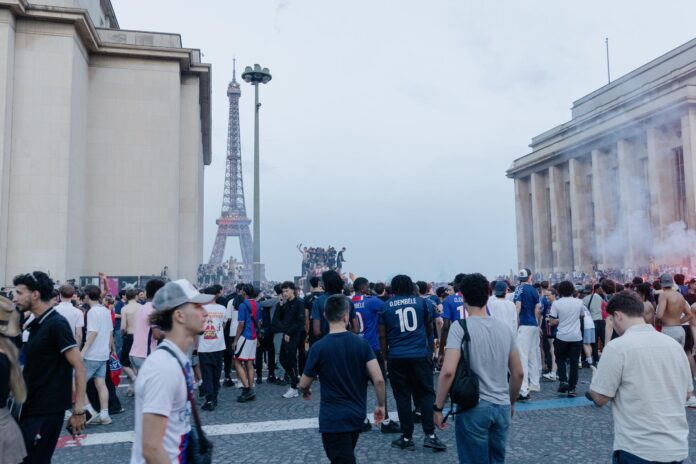 Los aficionados del PSG celebran la victoria de su equipo ante el Arsenal cerca del Trocadero y la Torre Eiffel. EFE/EPA/VALENTINA CAMU
