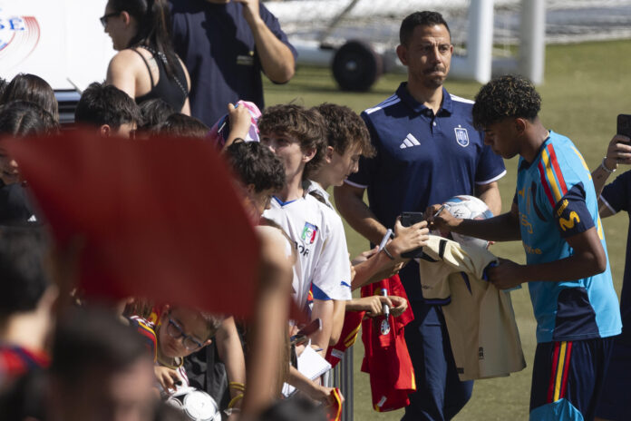 El delantero de la selección española de fútbol Lamine Yamal firma autógrafos antes del entrenamiento en la Ciudad del Fútbol en Las Rozas. EFE/Sergio Pérez
