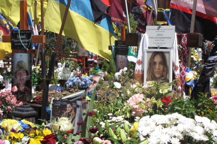 Vista de la tumba de la paramédica Irina Tsibuj en Leópolis. El legado de esta médica de combate ucraniana que murió en 2024 en el frente oriental de Járkov ayuda a transformar la forma en que miles de familias recuerdan a sus seres queridos fallecidos en la guerra de Rusia, al convertir el dolor en acciones positivas, incluidas benéficas. Miles de personas vestidas con trajes tradicionales se reunieron en el museo al aire libre de arquitectura popular de Leópolis durante el Cheka Fest para conmemorar el segundo aniversario de su muerte, que se produjo poco antes de cumplir 26 años. EFE/ Rostyslav Averchuk
