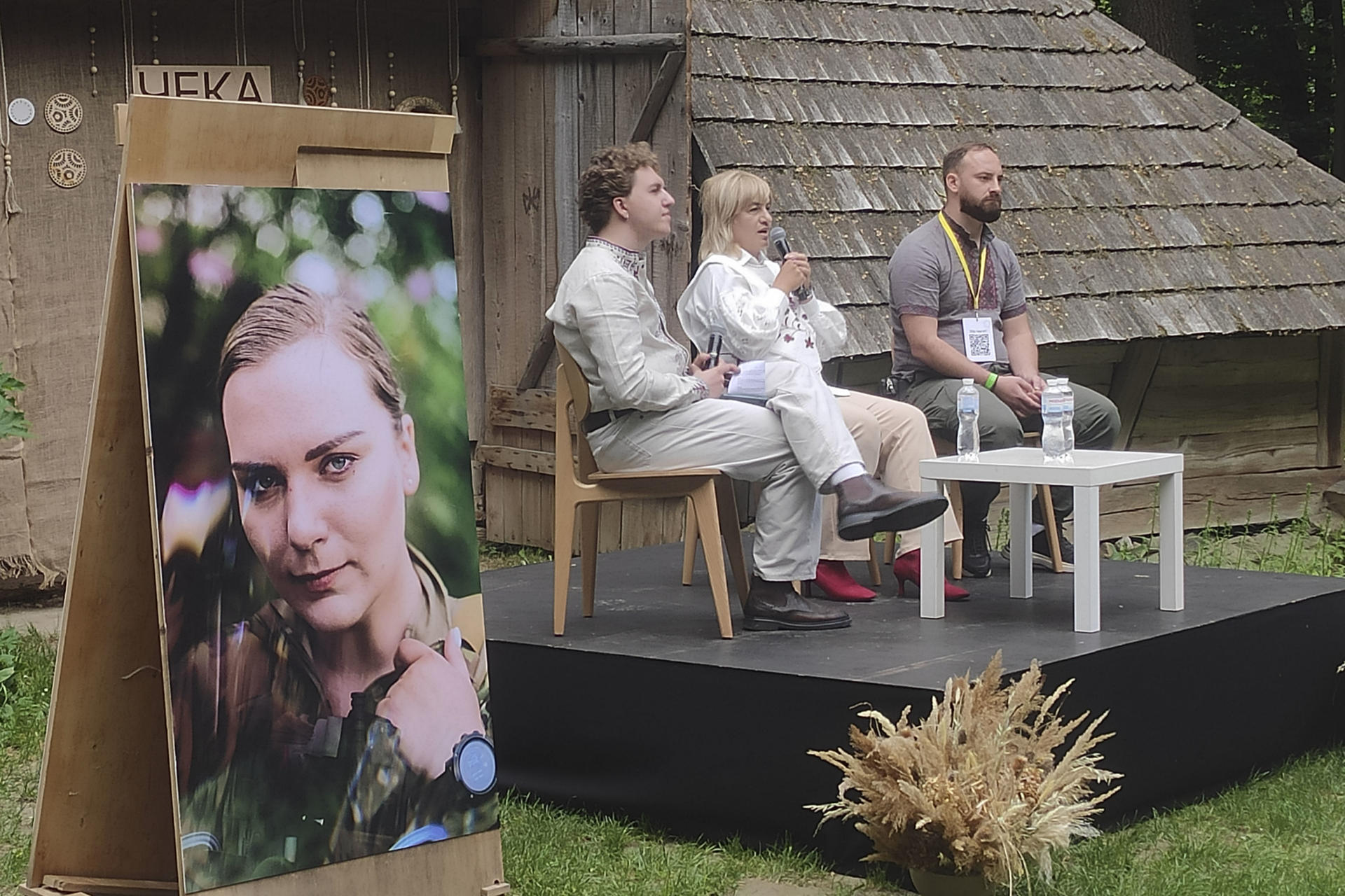 Yuriy (i), hermano de la paramédica Irina Tsibuj, junto a Oksana, la madre, y Taras, su compañero de trabajo en el frente, atienden a la prensa. El legado de esta médica de combate ucraniana que murió en 2024 en el frente oriental de Járkov ayuda a transformar la forma en que miles de familias recuerdan a sus seres queridos fallecidos en la guerra de Rusia, al convertir el dolor en acciones positivas, incluidas benéficas. Miles de personas vestidas con trajes tradicionales se reunieron en el museo al aire libre de arquitectura popular de Leópolis durante el Cheka Fest para conmemorar el segundo aniversario de su fallecimiento, que se produjo poco antes de cumplir 26 años. EFE/ Rostyslav Averchuk
