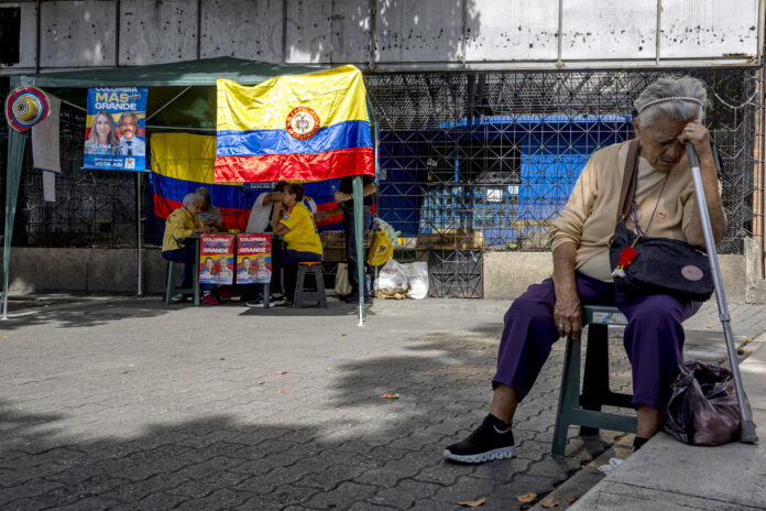 Una persona espera cerca a un puesto de votación durante la jornada electoral en Caracas (Venezuela). EFE/ Miguel Gutiérrez
