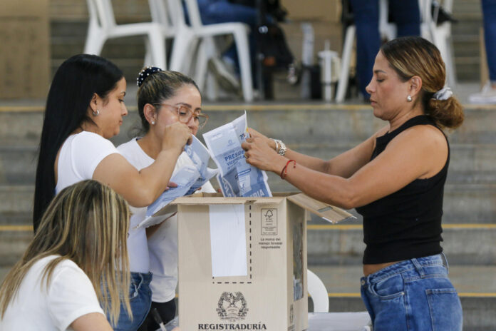 Personas cuentan votos durante la jornada electoral este domingo en Medellín (Colombia). EFE/STR
