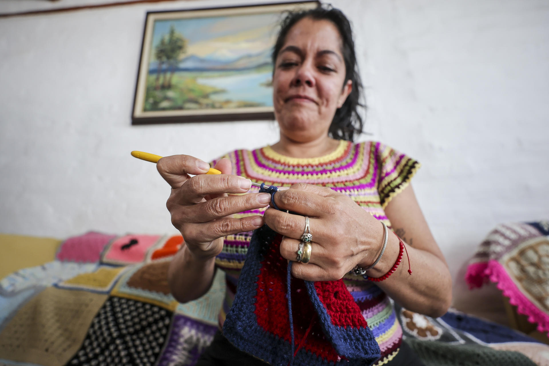 Fotografía tomada el pasado 19 de mayo en la que se captó a Rossana Almeida, integrante de una red de tejedoras de cobijas que comparten sus tejidos con personas que se recuperan de enfermedades, en Quito (Ecuador). EFE/José Jácome
