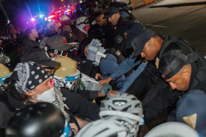 Agentes de la Policía Estatal de Nueva Jersey fueron captados este 30 de mayo al enfrentarse con manifestantes a las afueras de la Delaney Hall Detention Facility, en Newark (NJ, EE.UU.). EFE/Olga Federova
