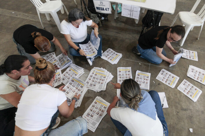 Personas cuentan votos durante la jornada electoral ayer domingo en Medellín (Colombia). EFE/STR
