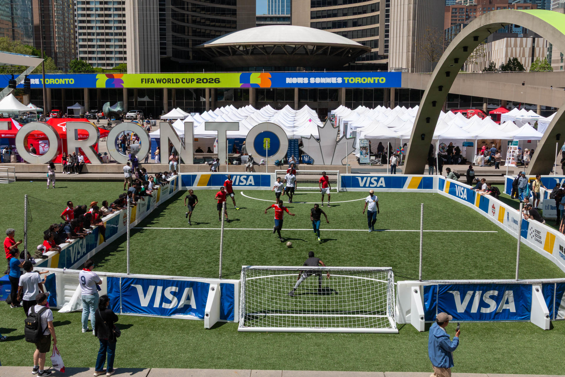 Fotografía que muestra personas jugando fútbol frente al ayuntamiento de Toronto (Canadá). EFE/ Julio César Rivas
