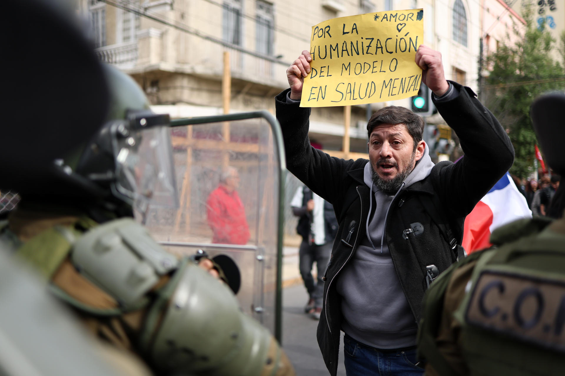 Un hombre sostiene un cartel en una manifestación a las afueras del Congreso Nacional durante el primer discurso de Presidente de Chile, José Antonio Kast, este lunes en Valparaíso (Chile). EFE /Javier Torres
