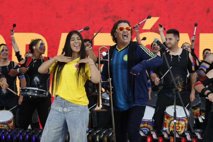Los artistas colombianos Carlos Vives (c) y María Fuell (c-i) cantan este lunes antes del partido amistoso entre Colombia y Costa Rica previo a la Copa Mundial de Fútbol de 2026, en el estadio El Campín en Bogotá. EFE/ Mauricio Dueñas Castañeda
