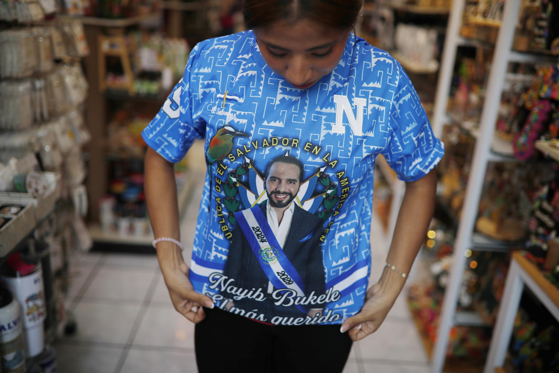 Una mujer muestra una camiseta con la fotografía del presidente de El Salvador, Nayib Bukele, en San Salvador (El Salvador). EFE/ Rodrigo Sura
