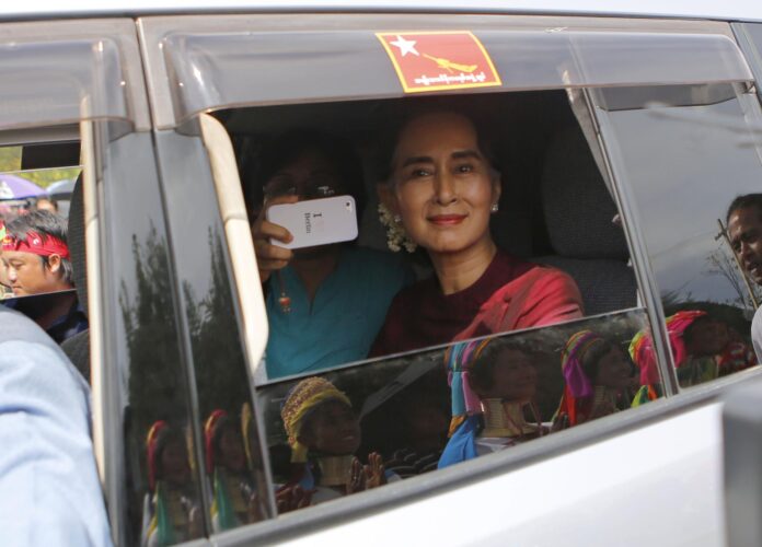 Imagen de archivo de la líder de la oposición birmana, Aung San Suu Kyi, antes de pronunciar un discurso mientras mujeres de la etnia Padaung que la reciben se reflejan en la ventana de su vehículo durante una campaña electoral oficial en el municipio de Demoso, estado de Kayah, al este de Birmania, el 10 de septiembre de 2015. 
EFE/EPA/LYNN BO BO
