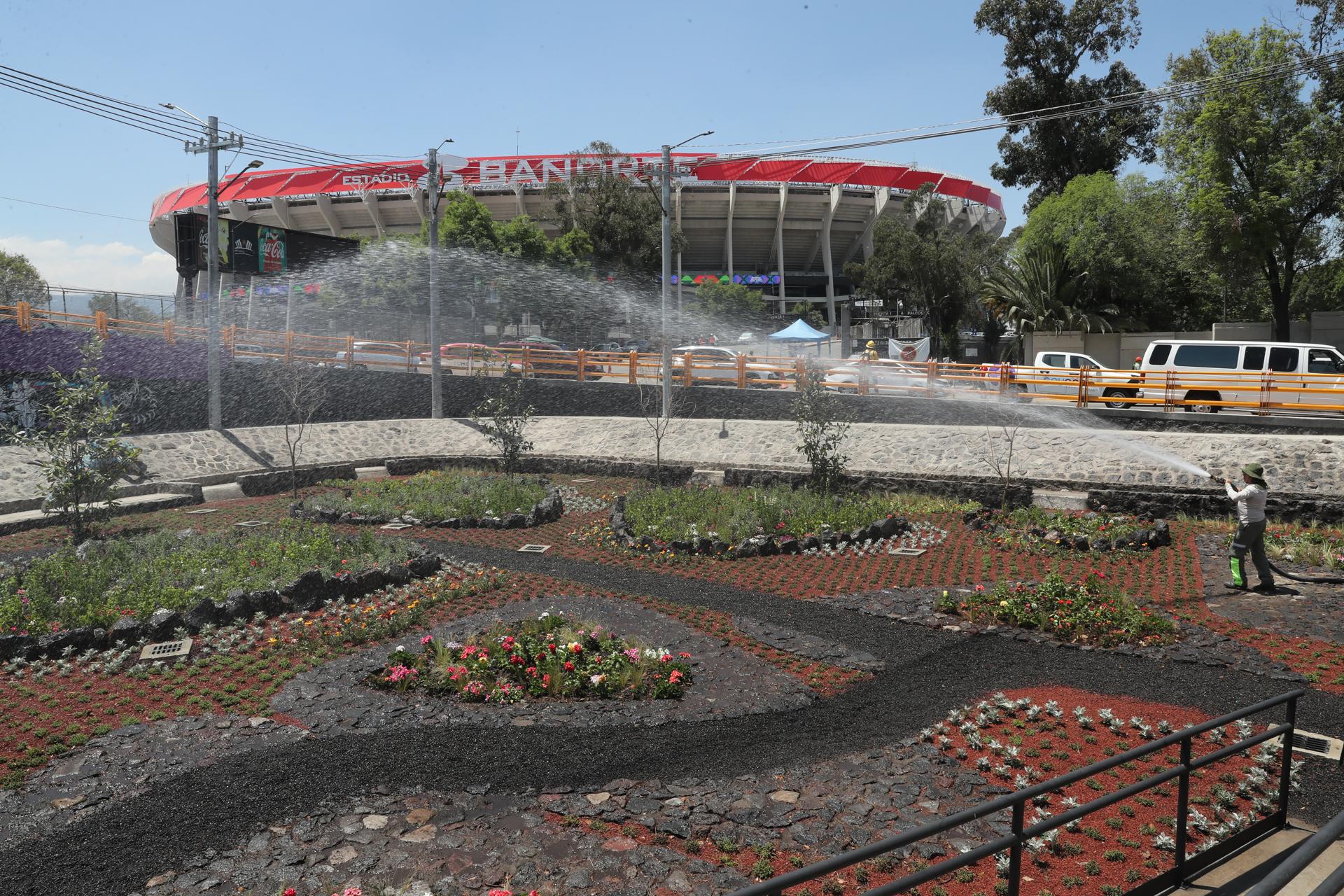 Fotografía de Mario Guzmán, en la que puede verse en una imagen de archivo del pasado 27 de marzo a una persona regando frente a la fachada del Estadio Azteca (Banorte), en Ciudad de México (México). EFE
