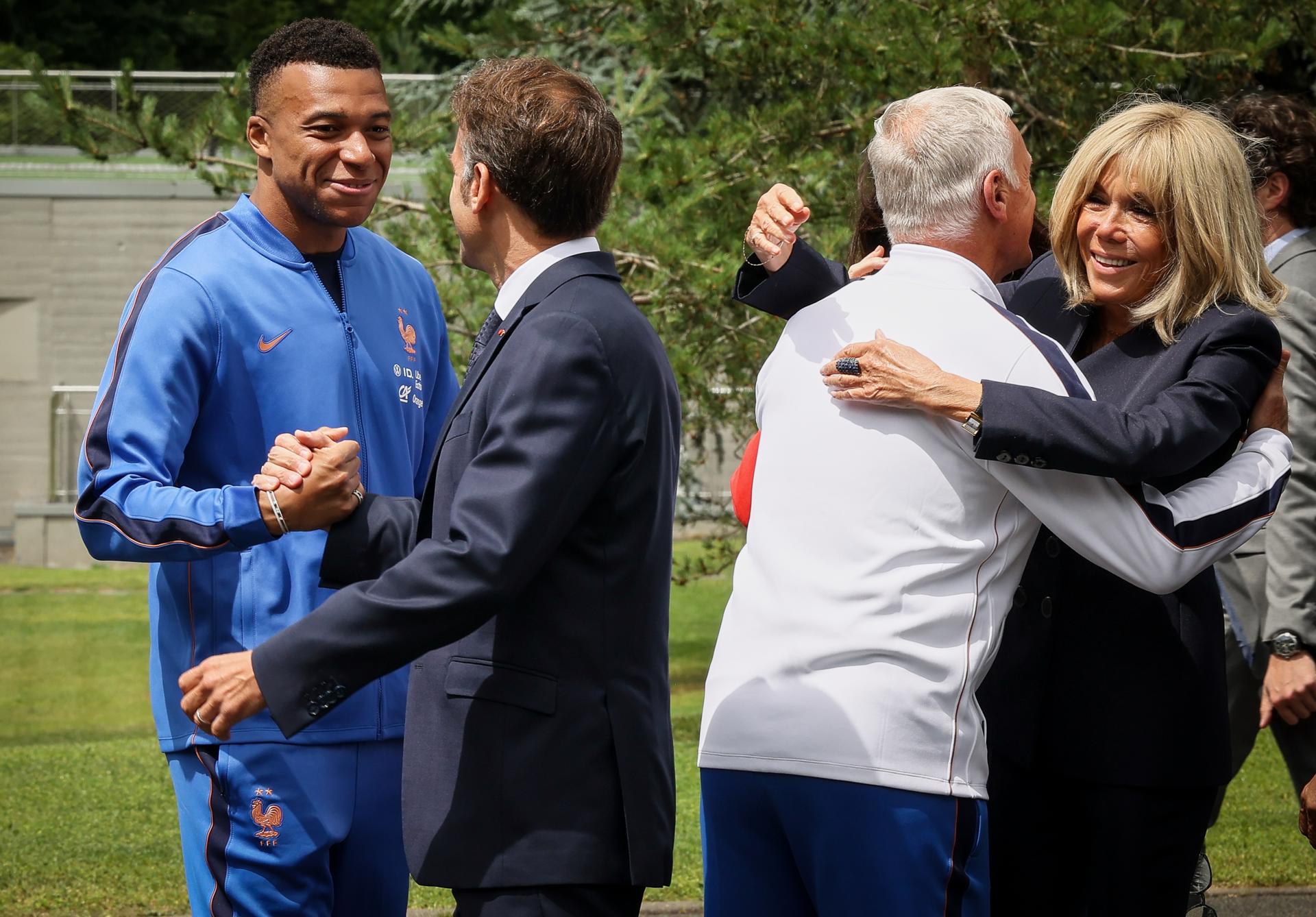 El presidente de Francia, Emmanuel Macron, y su esposa, Brigitte Macron, saludan al futbolista Kylian Mbappe (i) y al seleccionador, Didier Deschamps (2d) en la concentración del equipo con vistas al Mundial 2026 en Clairefontaine, oeste de París, este martes. EFE/ THOMAS PADILLA / POOL *MAXPPP OUT*
