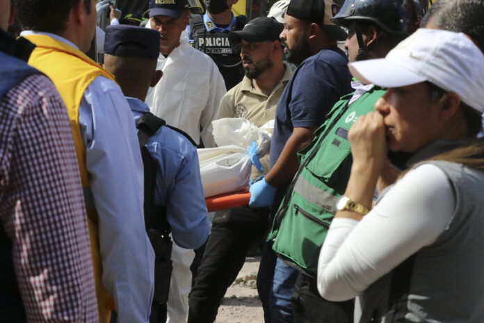 Socorristas de Honduras fueron captados este 1 de junio al cargar el cuerpo de una de las víctimas mortales del accidente de una volquete, en Tegucigalpa (Honduras). EFE/STR
