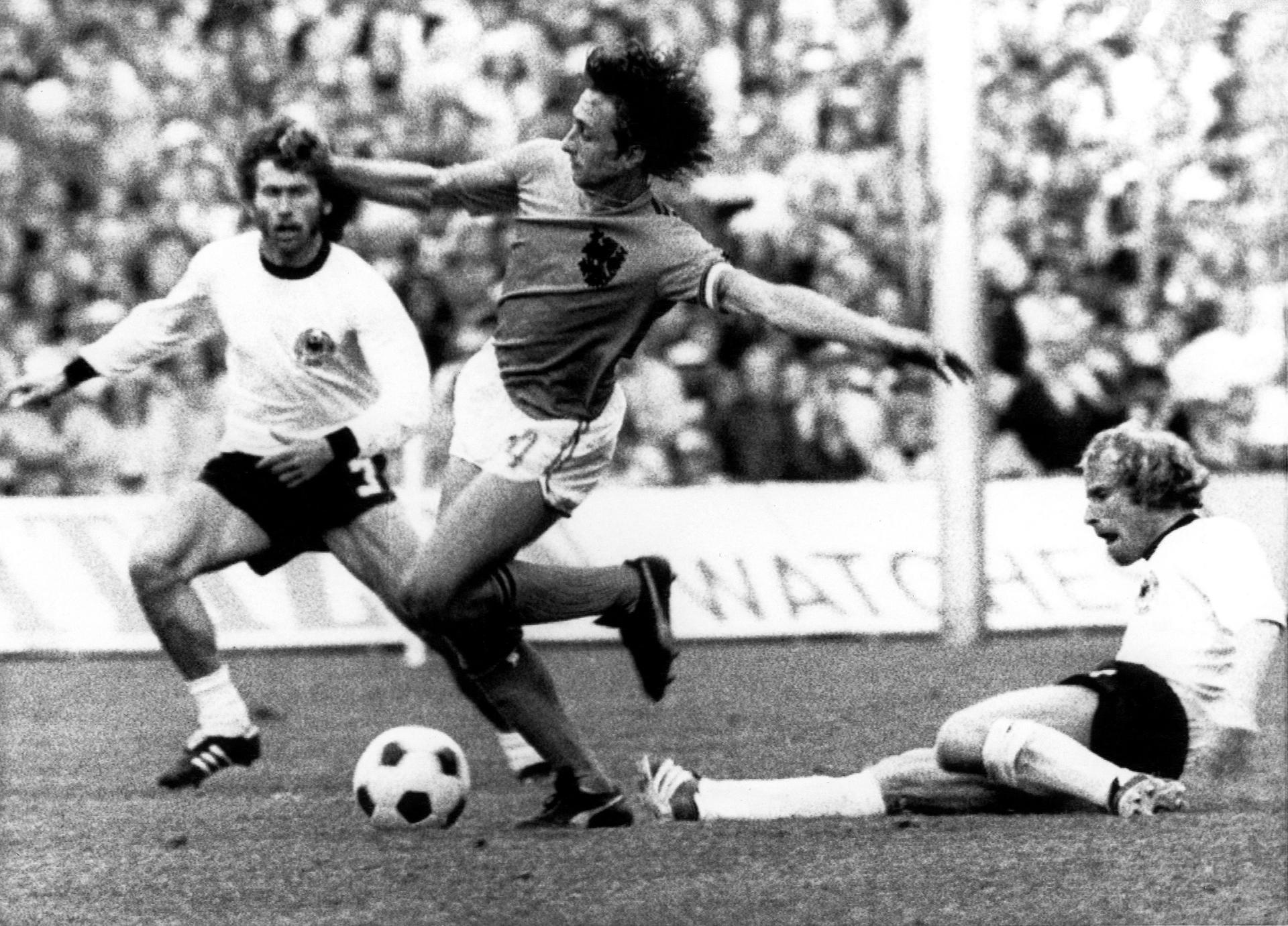 Fotografía de archivo tomada el 7 de julio de 1974 que muestra a los defensas alemanes Paul Breitner (i) y Berti Vogts (d) que luchan por el balón con el holandés Johan Cruyff (c) durante la final de la Copa del Mundo de 1974 entre Alemania y Holanda en Múnich (Alemania). EFE/Staff
