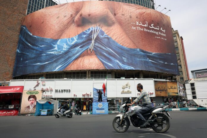 Los iraníes conducen frente a una gran valla publicitaria antiestadounidense con el presidente de Estados Unidos, Donald Trump, y el Estrecho de Ormuz en la Plaza Valiasr de Teherán, Irán, (Teherán) EFE/EPA/ABEDIN TAHERKENAREH RESTRICCIONES: NO Acceso Medios Israel/Estaciones de Televisión en Persa Fuera de Irán/Estrictamente NO Acceso BBC Persa/VOA Persa/Manoto TV/Iran International TV. (Según lo ordenado por la Dirección General de Medios Extranjeros de Irán) --
