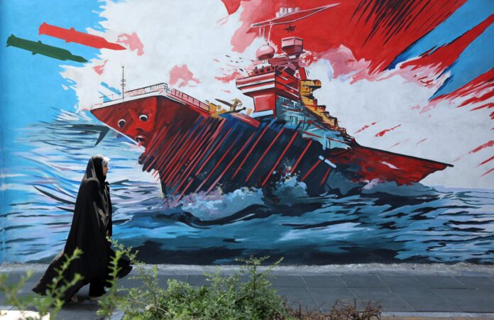Una mujer pasa este miércoles delante de un mural en Teherán. EFE/EPA/ABEDIN TAHERKENAREH RESTRICCIONES: NO Acceso Medios Israelíes/Cadenas de Televisión en Persa Fuera de Irán/Estrictamente NO Acceso BBC Persa/VOA Persa/Manoto TV/Iran International TV. (Según lo ordenado por la Dirección General de Medios Extranjeros de Irán) --
