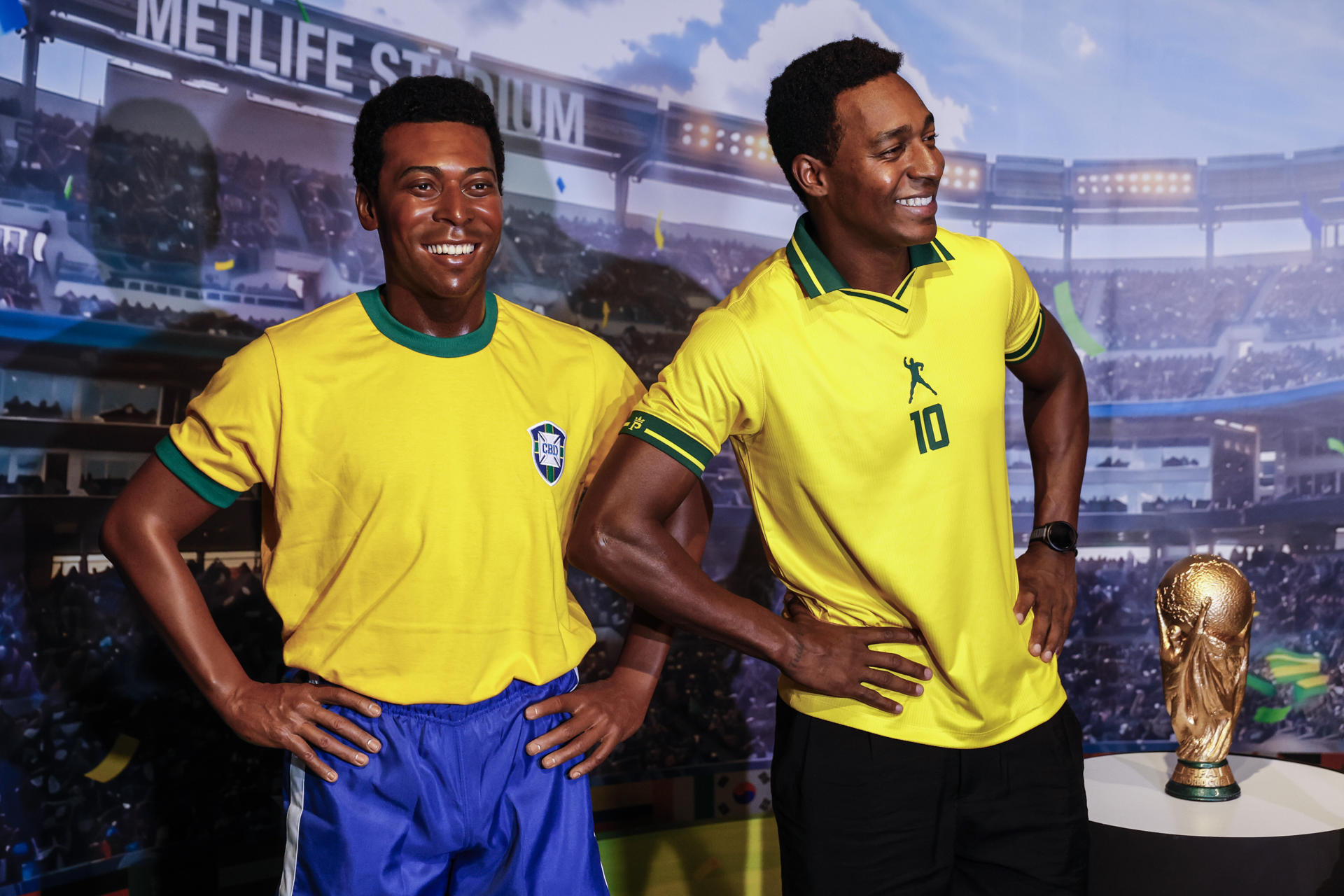 Fotografía que muestra un doble (d) de Pelé posando junto a la escultura del legendario futbolista brasileño exhibida en el Museo AquaRio en Río de Janeiro (Brasil). EFE/ Antonio Lacerda
