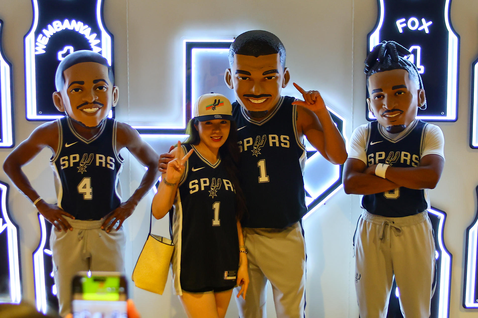 Una aficionada de los San Antonio Spurs posa este miércoles junto a estatuas en tamaño real de varios jugadores del equipo, previo al primer partido de las finales de la NBA. EFE/ Carlos Ramírez
