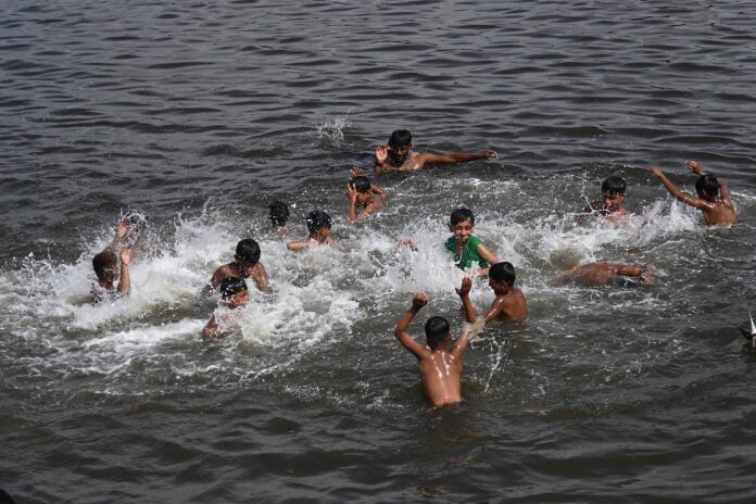 Unos niños se refrescan en el agua en una jornada muy calurosa en Karachi, Pakistan, en una imagen reciente. EFE/EPA/SHAHZAIB AKBER
