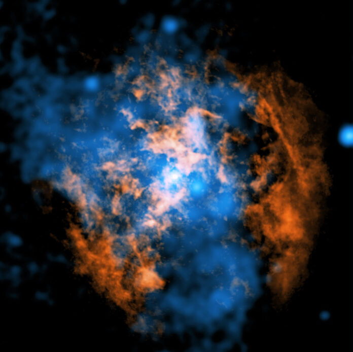 Esta imagen compuesta muestra evidencia de un viento que sopla alejándose de Sagitario A* (Sgr A*), el agujero negro supermasivo en el centro de nuestra galaxia. El punto blanco en el centro de la imagen muestra a Sgr A*. En naranja se presentan los datos de los radiotelescopios del Atacama Large Millimeter/Submillimeter Array (ALMA) en Chile, los cuales mapean la ubicación del gas frío compuesto de monóxido de carbono en la imagen. En azul se muestran los datos de rayos X del Observatorio de Rayos X Chandra de la NASA. Una gran cavidad en forma de cono, visible como una ausencia de gas frío en los datos de ALMA, está llena de gas caliente que emite rayos X en los datos de Chandra. Los investigadores piensan que un viento caliente y energético que sopla desde Sgr A* creó esta estructura al barrer el gas frío o al calentarlo. Rayos X: NASA/CXC/Northwestern Univ./M. Gorski; Radio: ESO/NAOJ/NRAO/ALMA; Procesamiento de imágenes: NASA/CXC/SAO/K. Arcand y P. Edmonds
